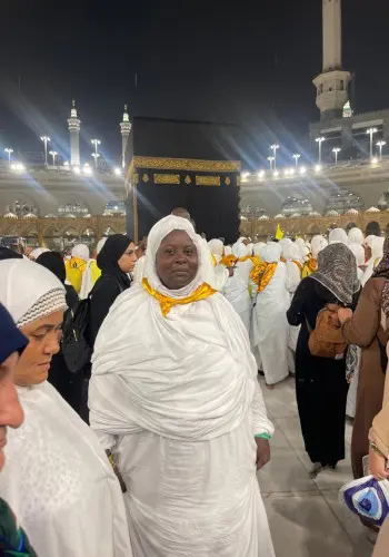 Pèlerine en tenue blanche devant la Kaaba