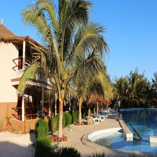 Allée de palmiers et piscine d'un hôtel du Lac Rose